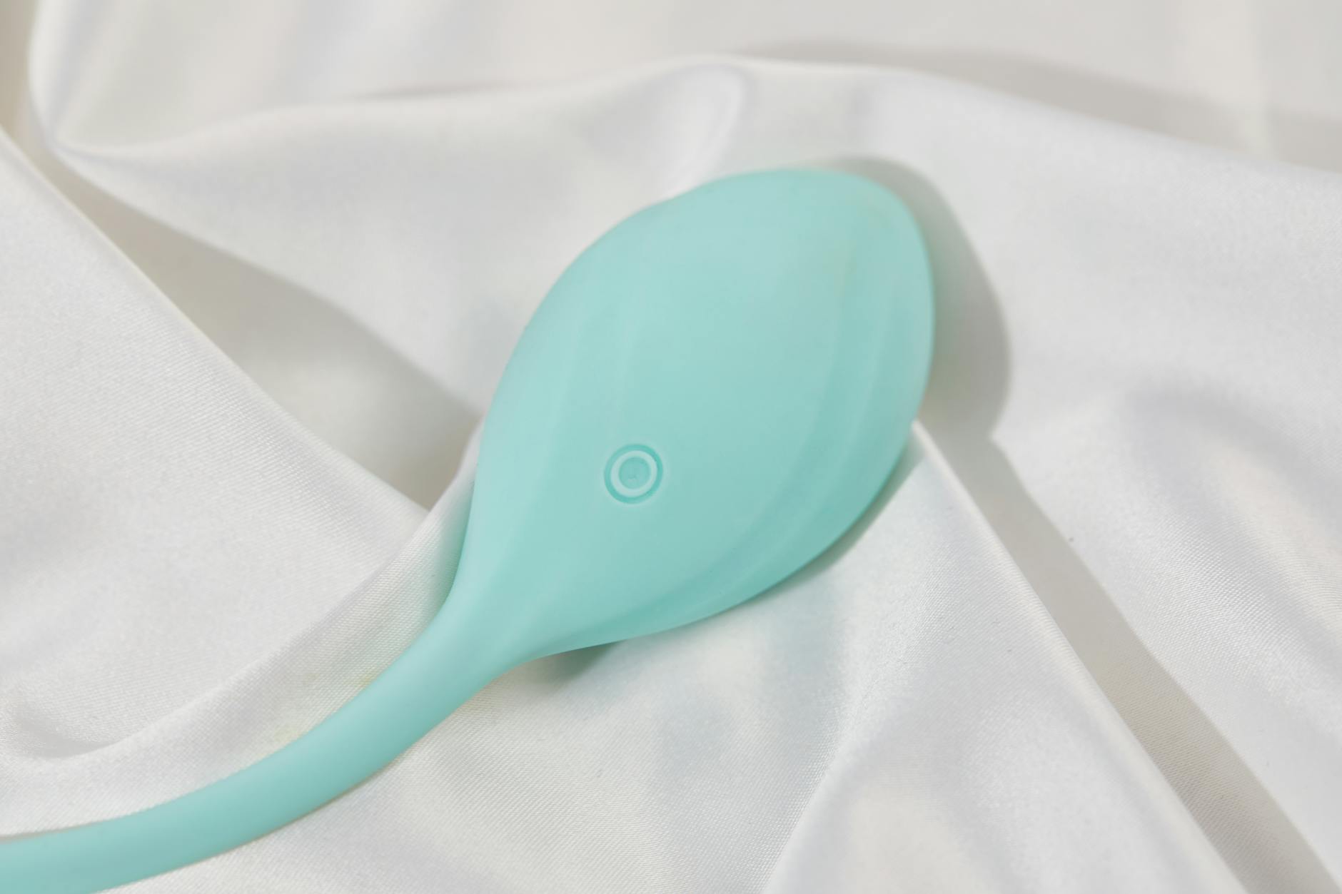 Vibratrice élégante sur tissu blanc lisse, symbolisant le plaisir raffiné et la sensibilité