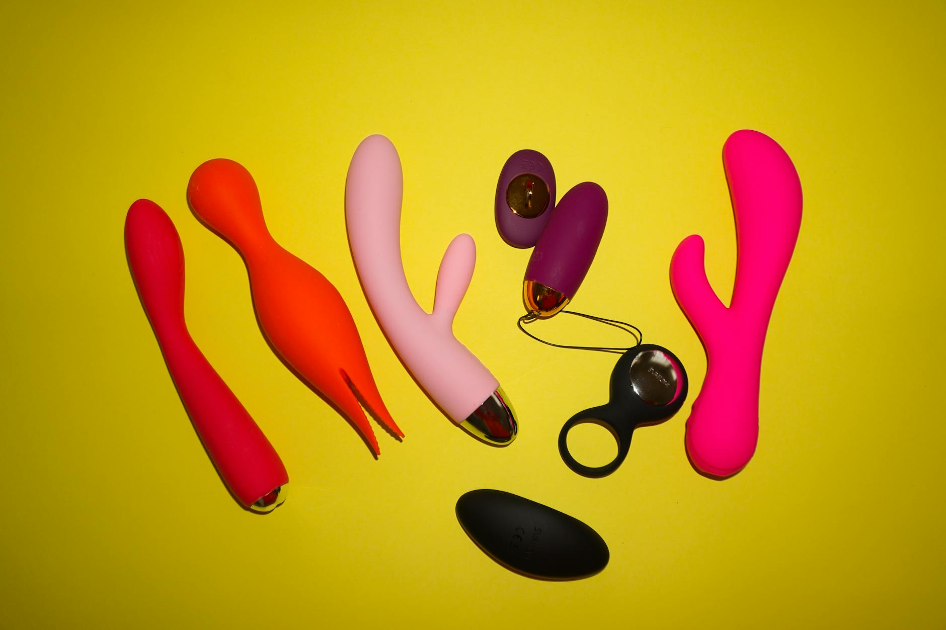 Vibrateur silicone jaune entouré de bananes sur fond jaune vif