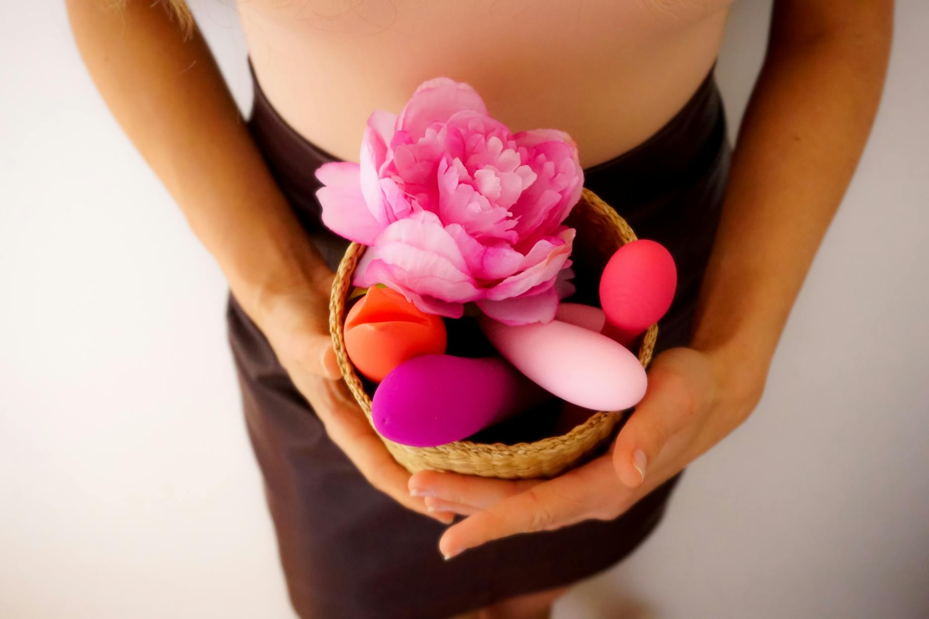 Femme tenant un vibrateur bleu et rose en silicone dans un moment introspectif