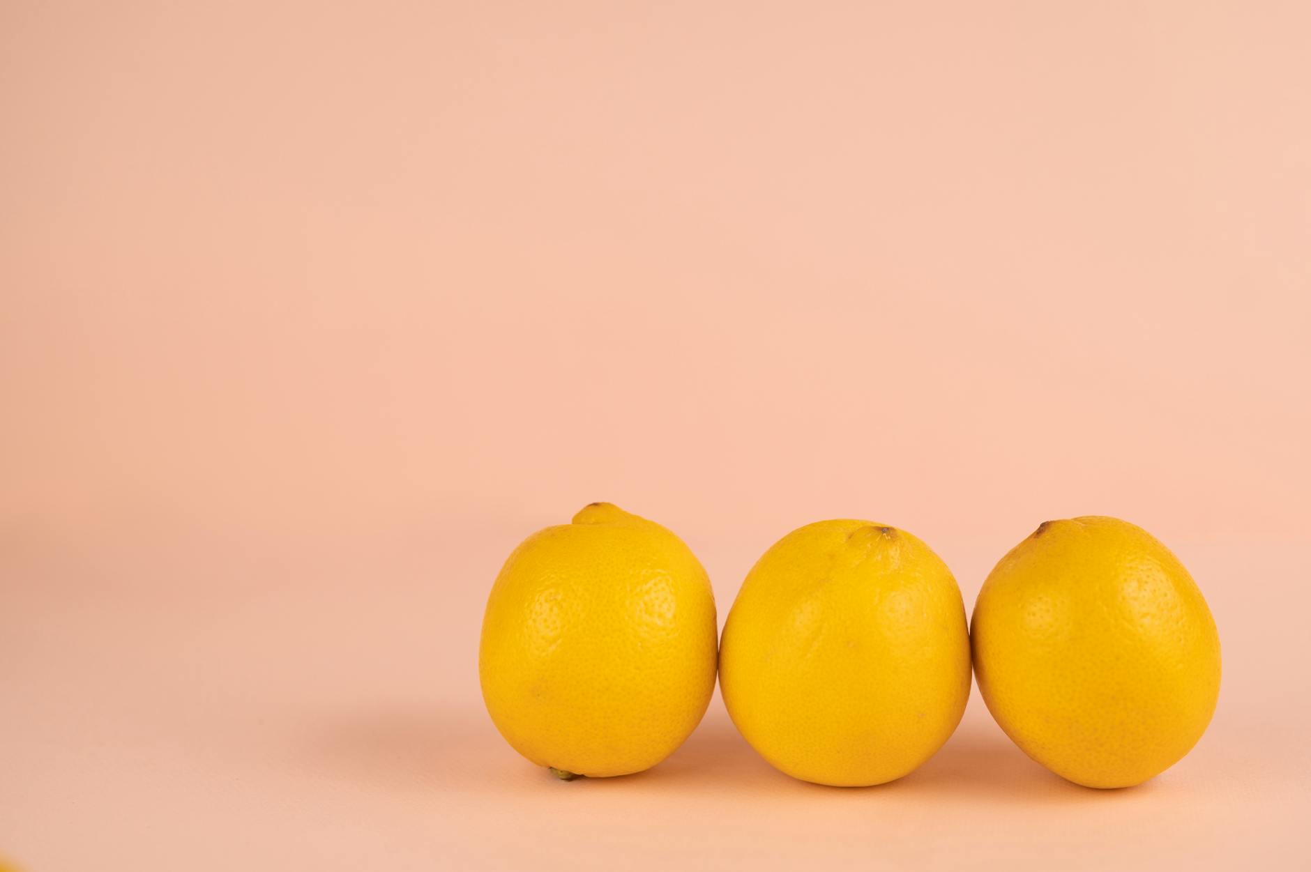 Citrons frais et vibrants disposés sur fond jaune clair, symbolisant la restauration et la vitalité pendant la périménopause